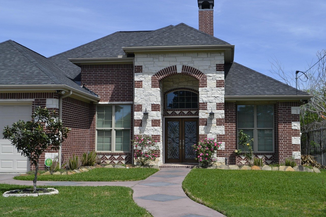 A brick home with a large decorative glass front door.